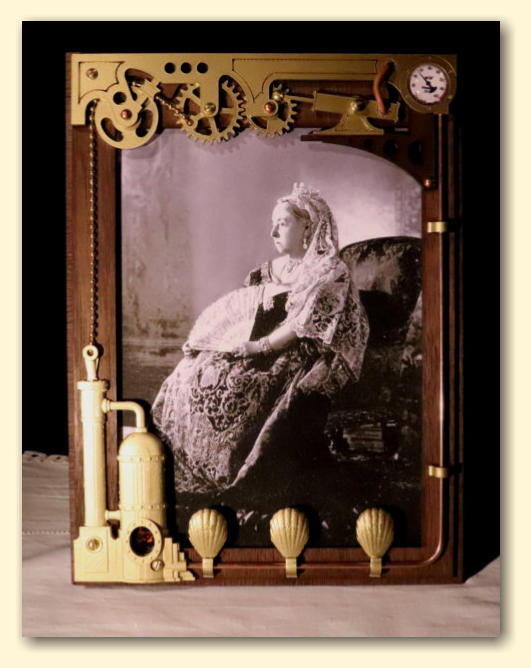The steampunk Victorian styled mechanical picture frame with gears, pistons, a gauge, boiler and brass chain
