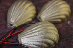 A closeup of three of the brass coloured miniature shell lamps