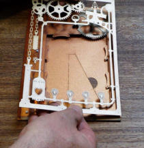 Hold the cutout above the foam pads and line up the nearest corner