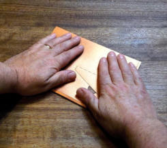 Turn it over, lay the front on the table and firmly smooth it down