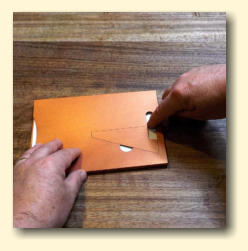 Carefully turn it over and press down the glue or tape through the slot at the bottom