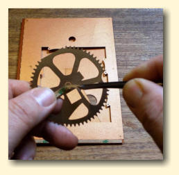 Peel the tape backing off the gear