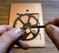 Peel the tape backing off the gear
