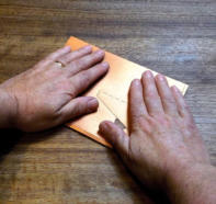 Turn it over, lay the front on the table and firmly smooth it down