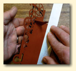 Line the ruler up with the fold marks on the slotted tab