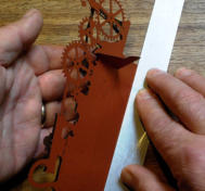 Line the ruler up with the fold marks on the slotted tab
